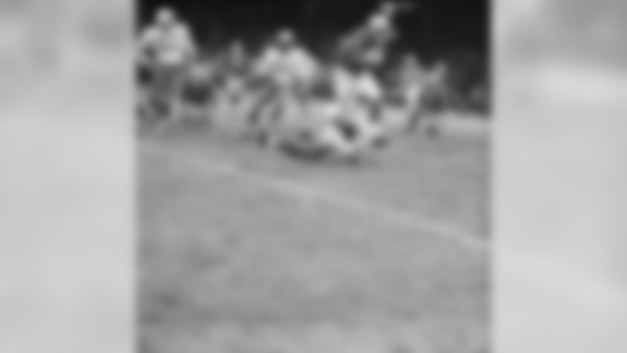 Detroit Lions halfback Dan Lewis (45) looks like he is about to be toppled by Chicago Cardinals back Jim Wagstaff (on ground), but Lewis was too fleet for him. He ran a good ten yards more in this fourth quarter play before another player nailed him. At rear is Cardinals linebacker Ted Bates (51). The Lions scored early and kept a healthy lead throughout the game to win 54-21, on Dec. 7, 1959 in Detroit.