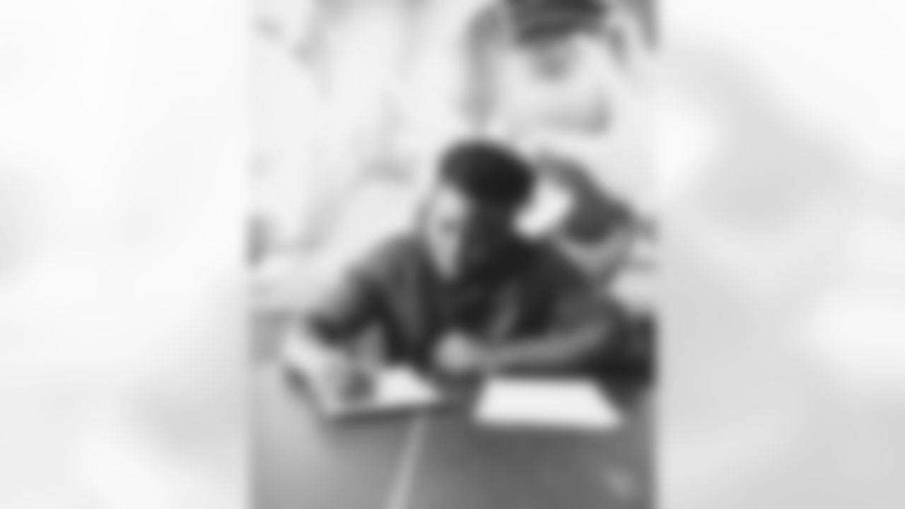 OLB Victor Dimukeje signs his contract.