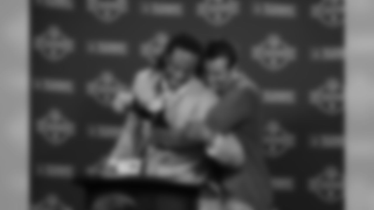 Kurt Warner gives Fitzgerald a hug at the press conference podium after the NFC Championship win