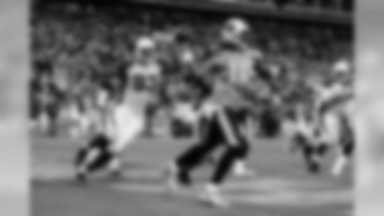 2009: Titans QB Vince Young throws the ball as Calais Campbell runs after him.