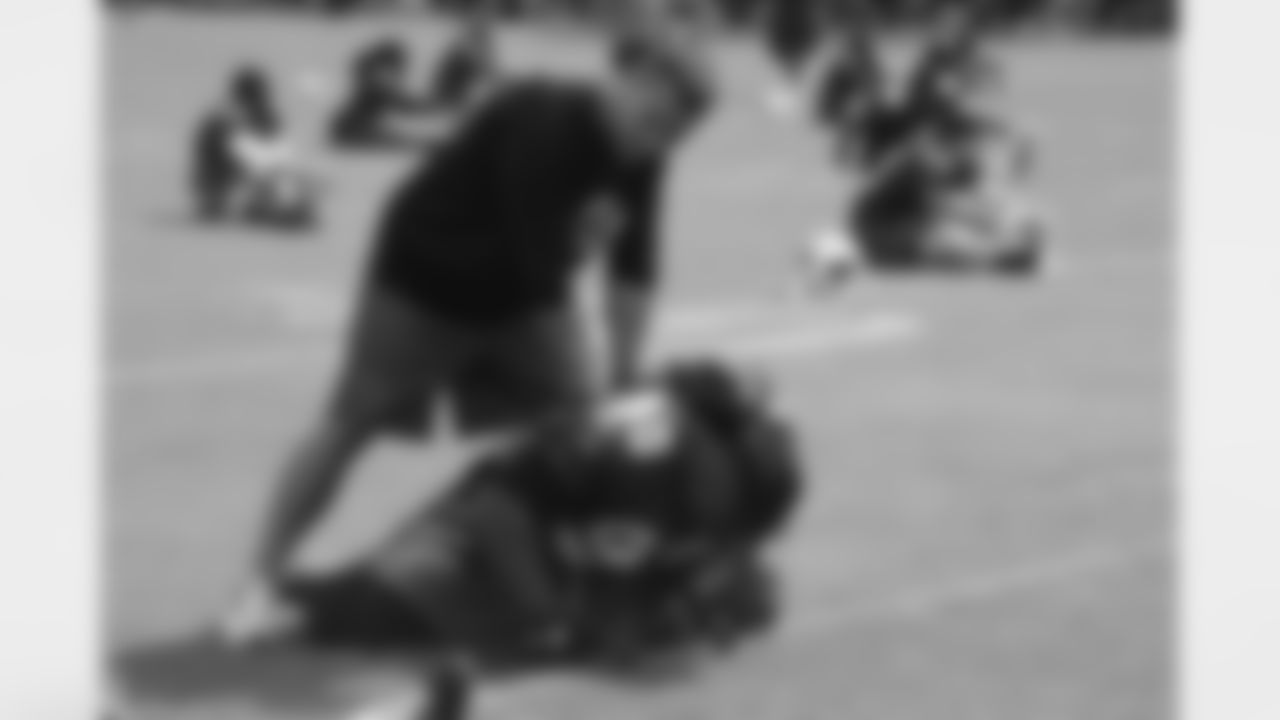 Assistant strength coach Pete Alosi helps Darnell Dockett stretch