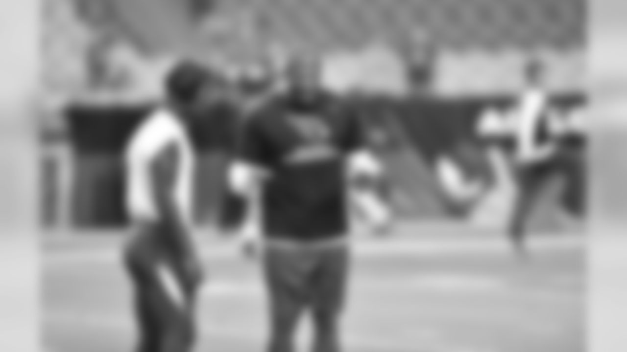 WR John Brown (left) speaks with speed coach Roger Kingdom before the Lions game