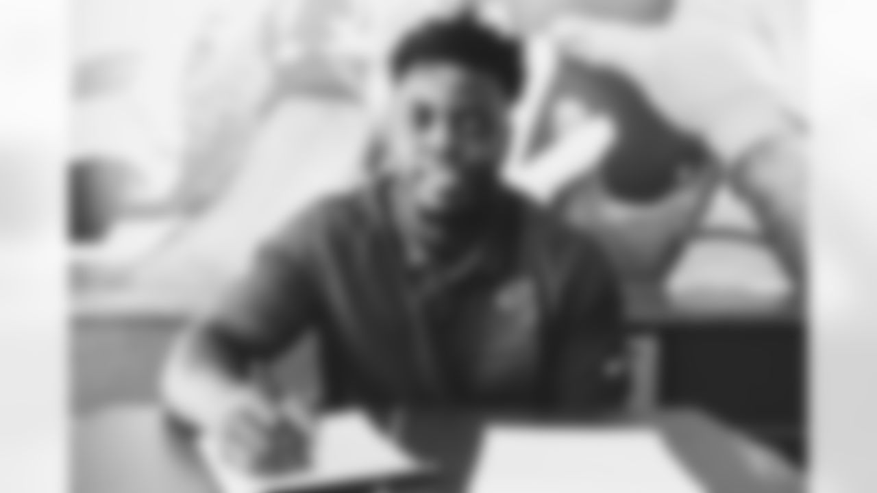 OLB Victor Dimukeje signs his contract.