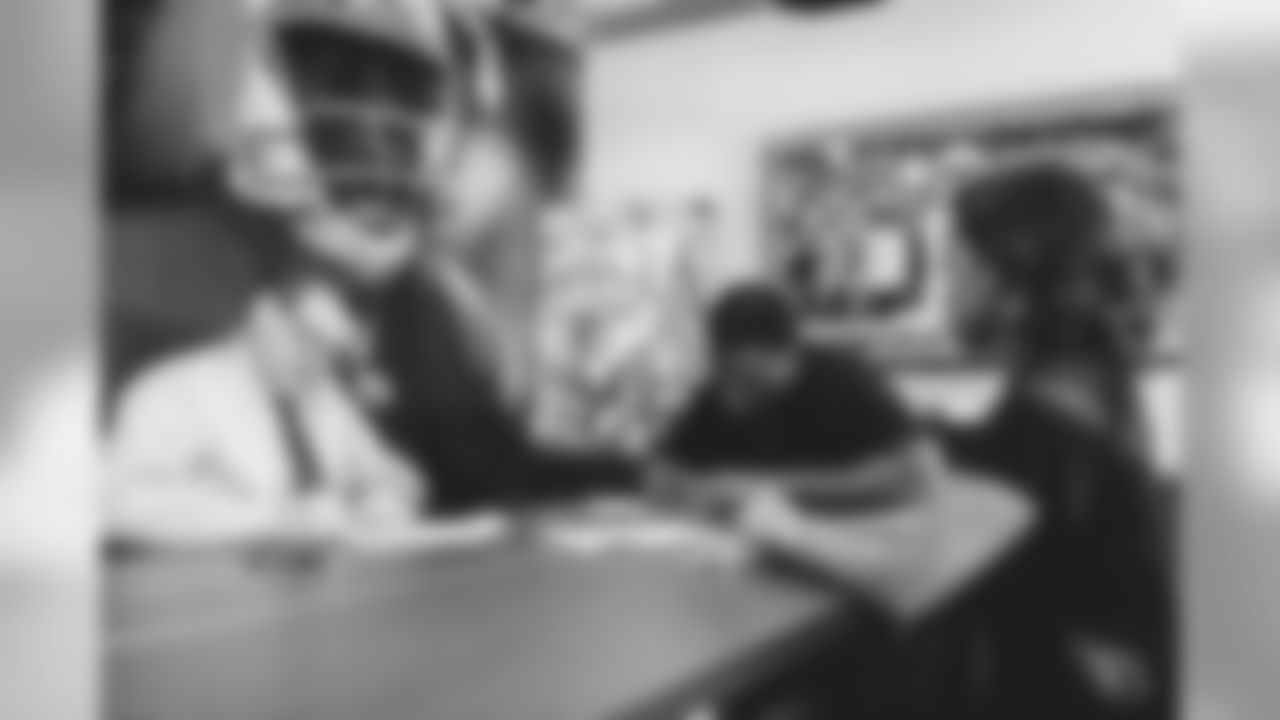 Images of T D.J. Humphries signing his three-year contract extension with the Cardinals and then meeting with the media