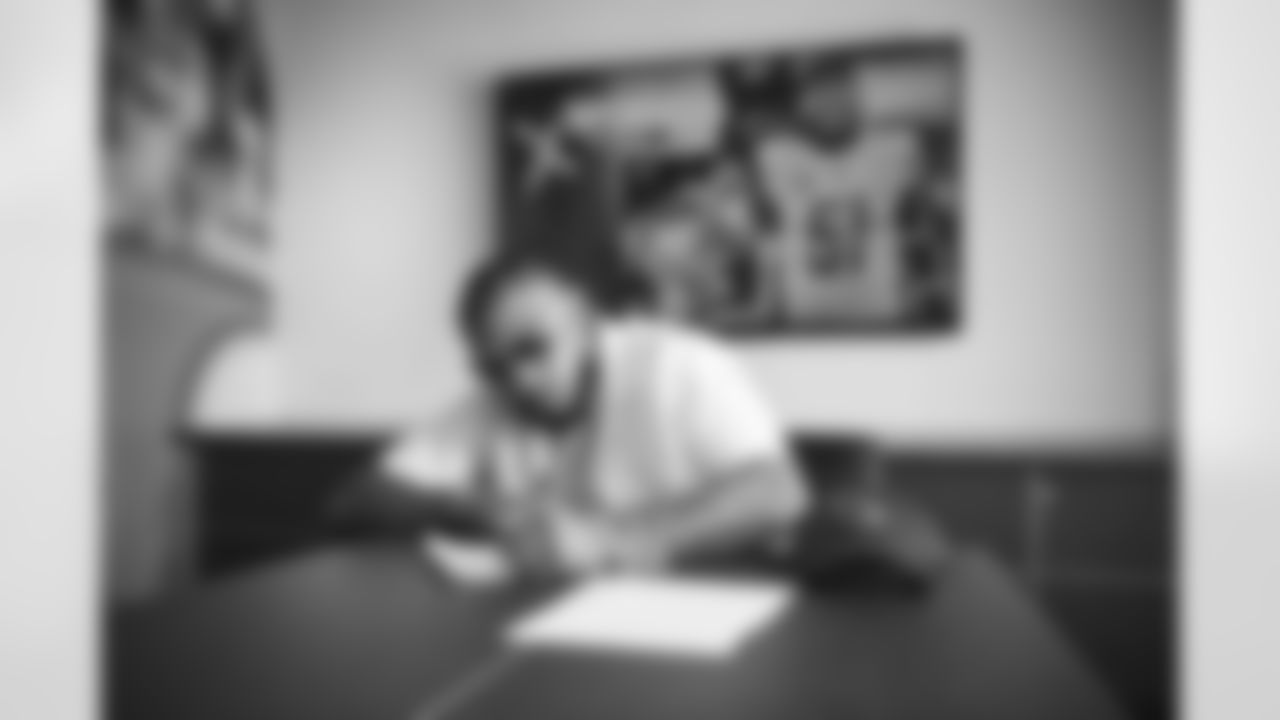 Linebacker Josh Woods signs a contract with the Arizona Cardinals at the Dignity Health Training Facility on Thursday, March 30, 2023.