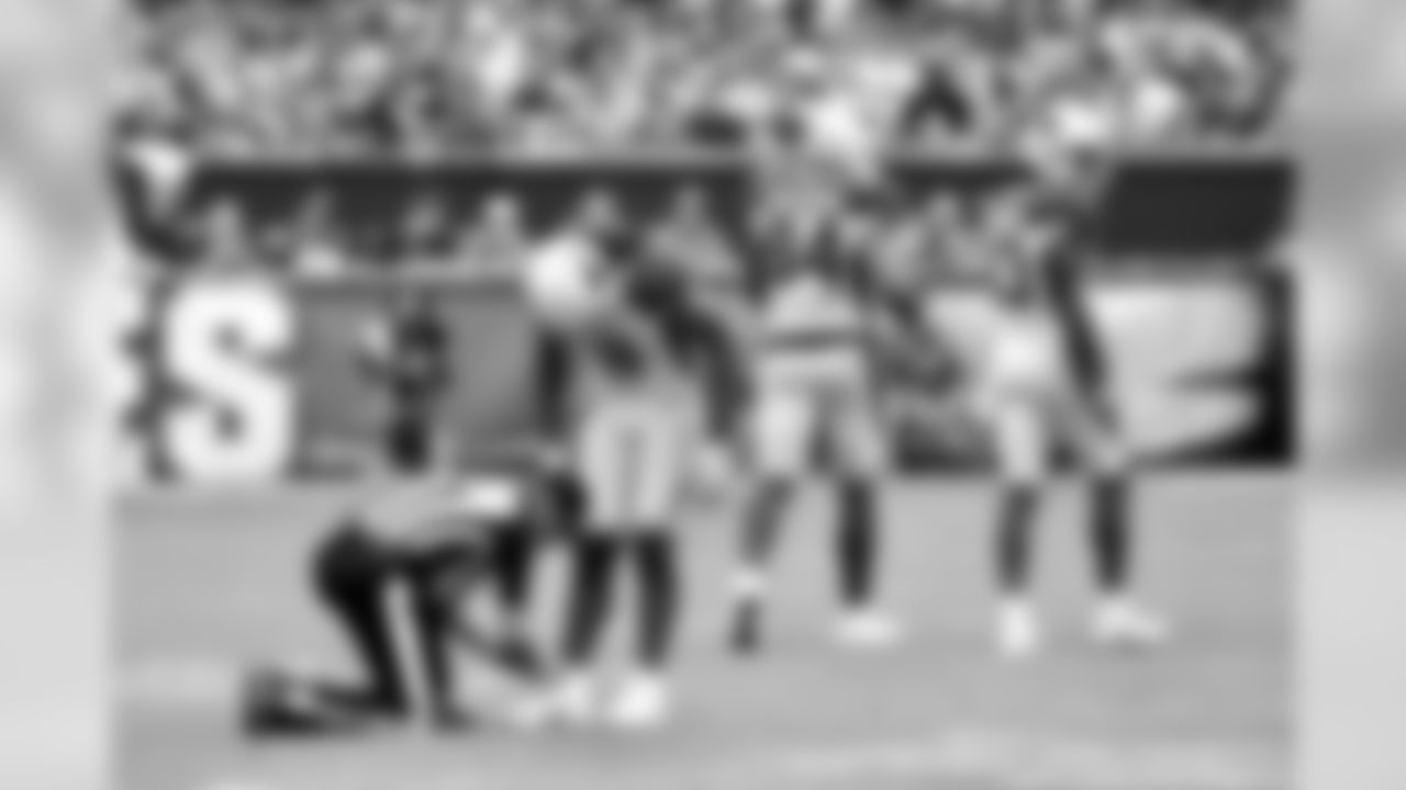 An official helps WR Larry Fitzgerald tie his shoe.