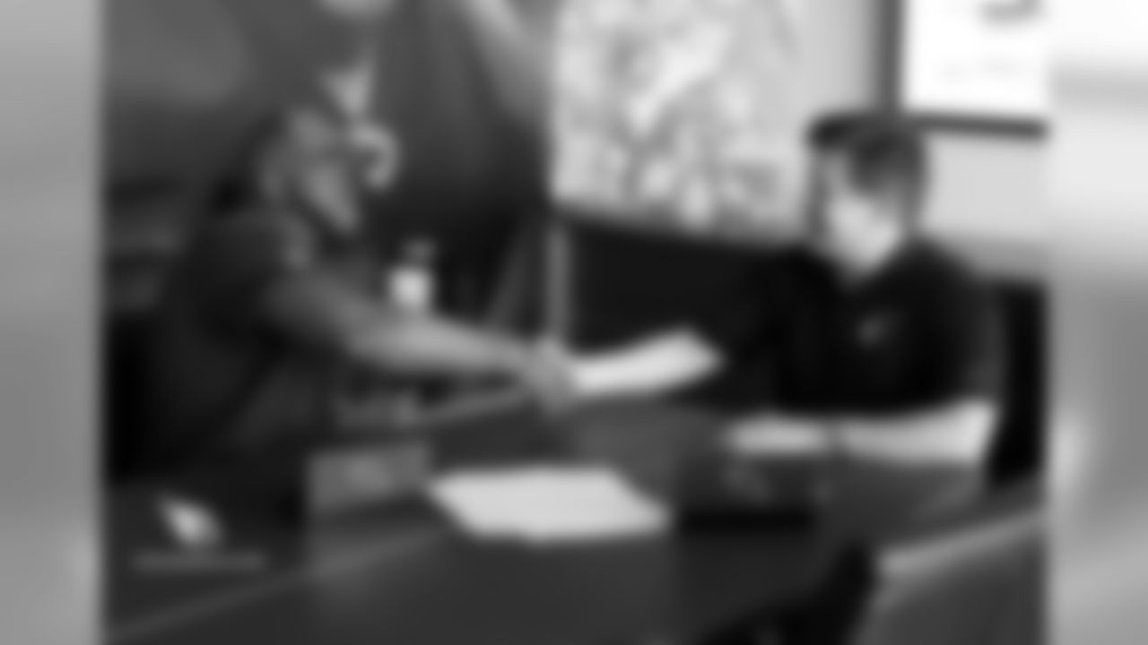 T Korey Cunningham shakes the hand of team president Michael Bidwill after signing his contract