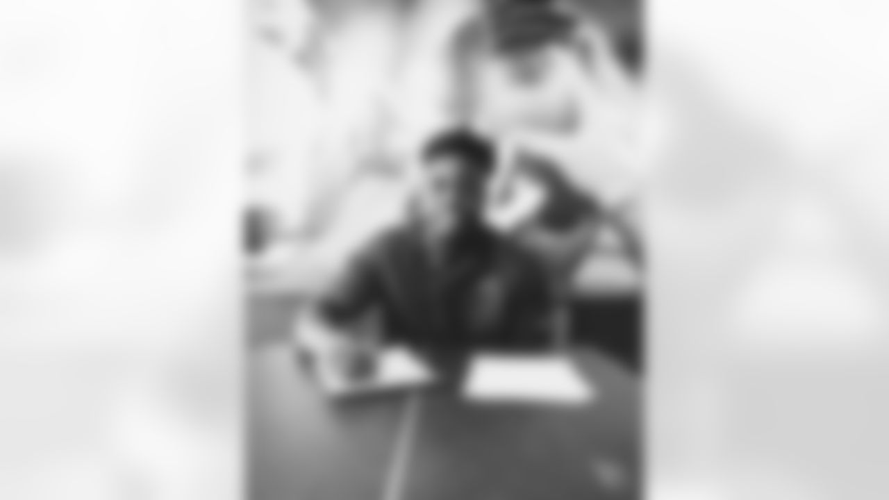 OLB Victor Dimukeje signs his contract.