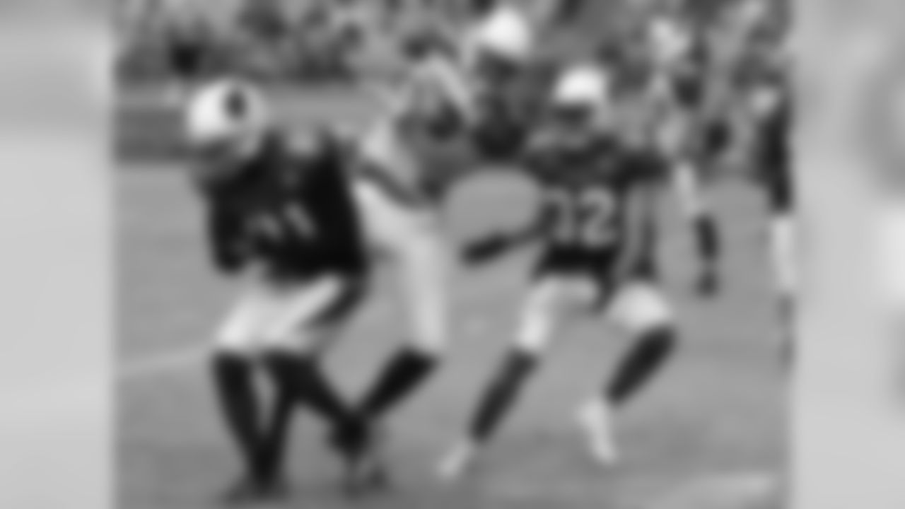WR Jaron Brown catches a pass in between CB Patrick Peterson and S Tyrann Mathieu