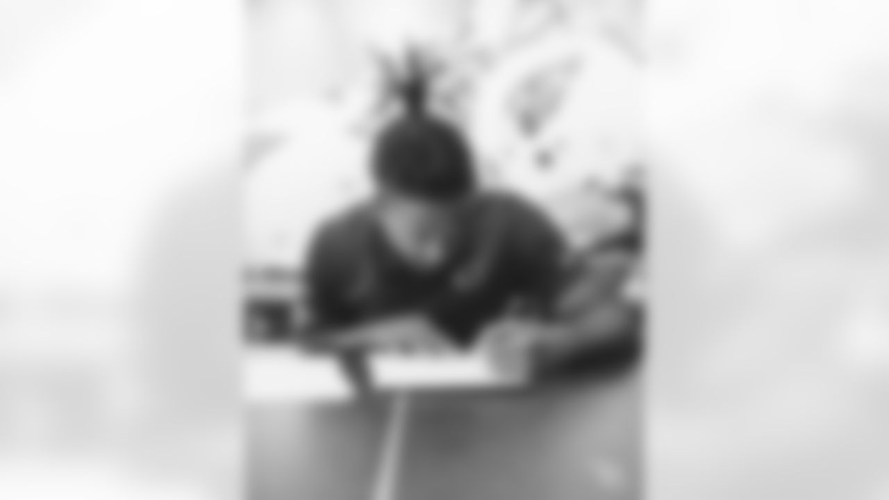 CB Marco Wilson signs his contract.