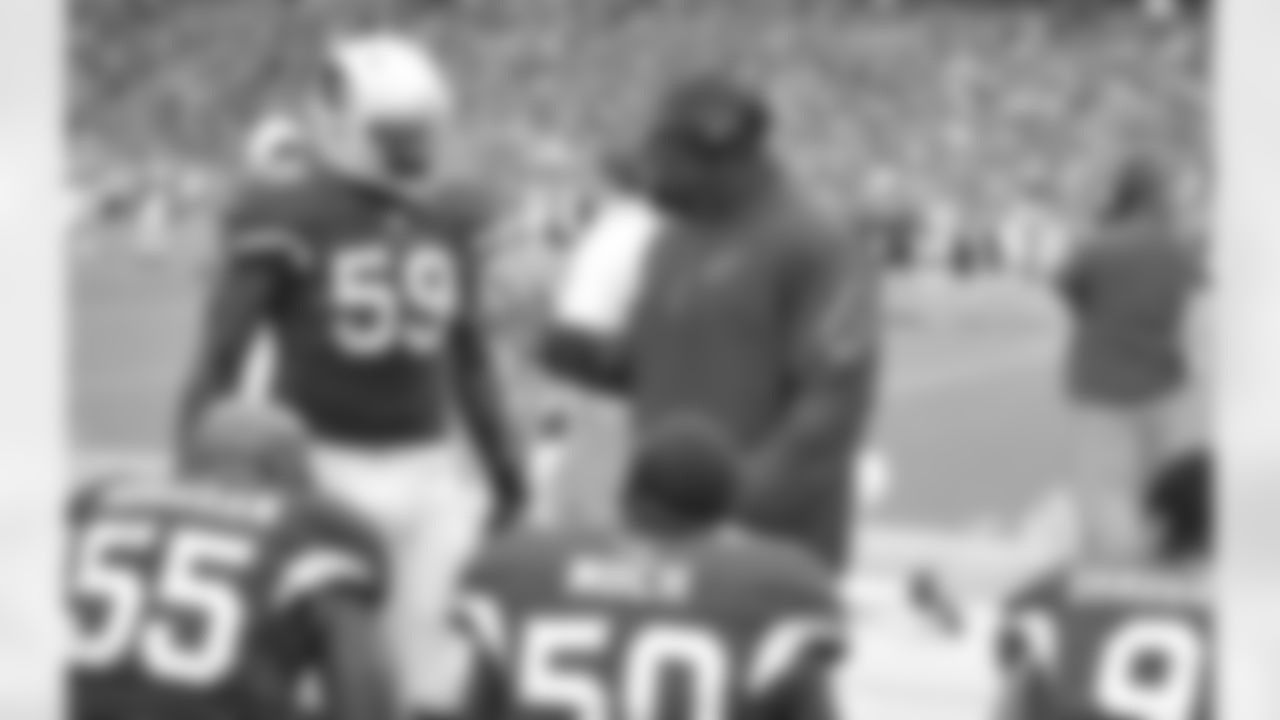 Defensive line coach Brentson Buckner and LB Marcus Benard converse during the Falcons game.