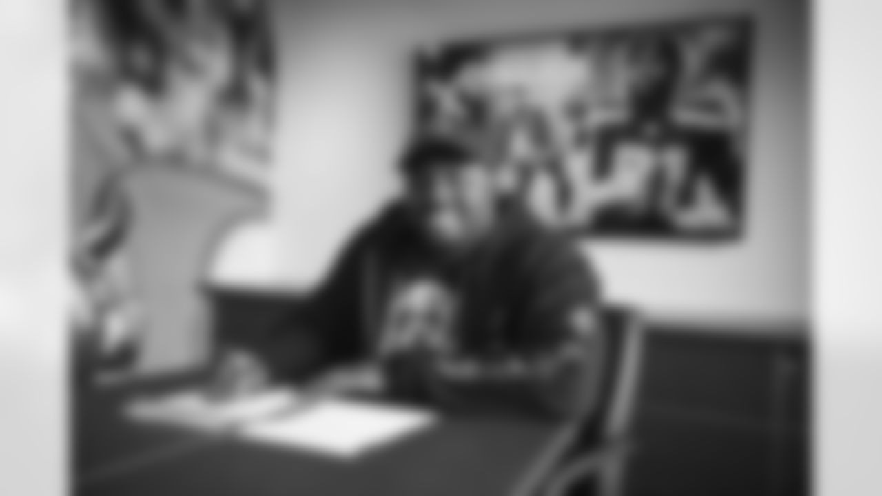 Defensive end L.J. Collier signs a contract with the Arizona Cardinals at the Dignity Health Training Facility on Wednesday, March 22, 2023.
