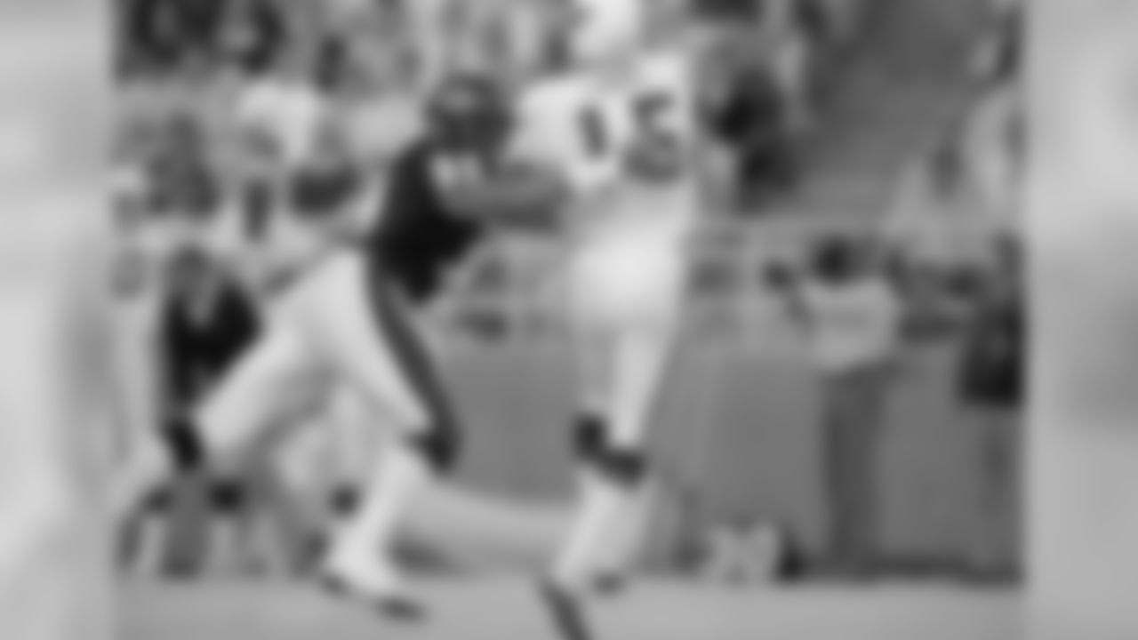 Chicago Bears Dan Hampton (99) grabs St. Louis Cardinals quarterback Neil Lomax after Lomax had tossed an incomplete pass during the first quarter in Chicago, Aug. 31, 1987.