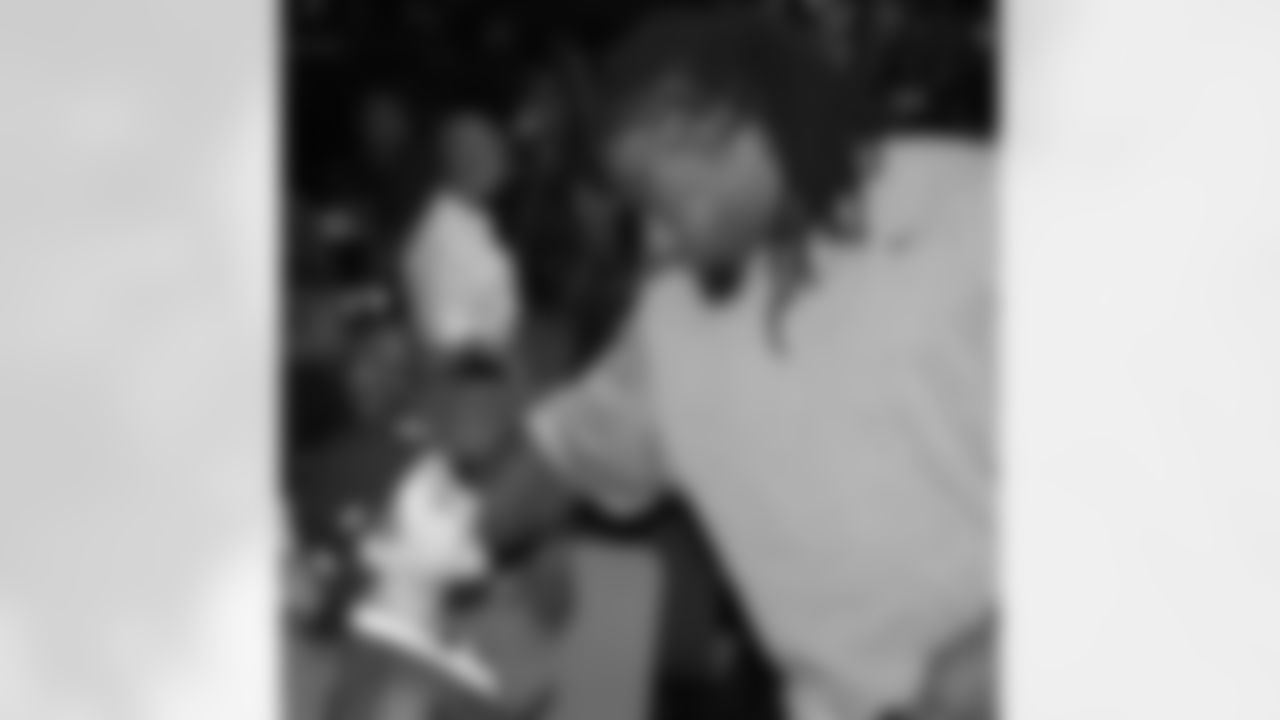 Darnell Dockett fixes the hat of a young fan