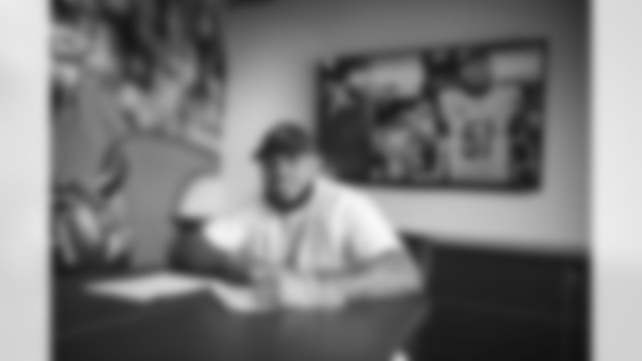 Linebacker Josh Woods signs a contract with the Arizona Cardinals at the Dignity Health Training Facility on Thursday, March 30, 2023.