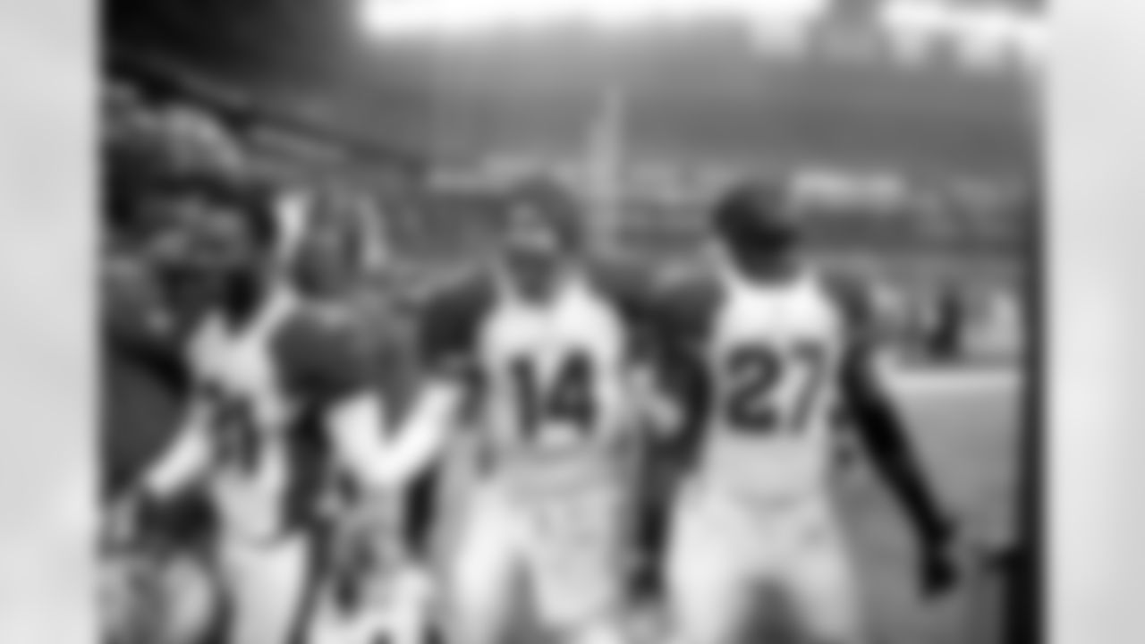 Bethel (left) walks off the field with QB Ryan Lindley (middle) and S Curtis Taylor after the upset win in Seattle in 2013