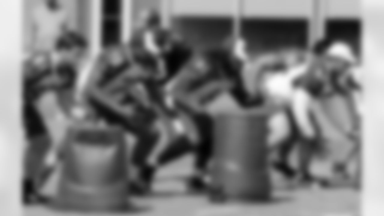 The offensive linemen push forward at the snap