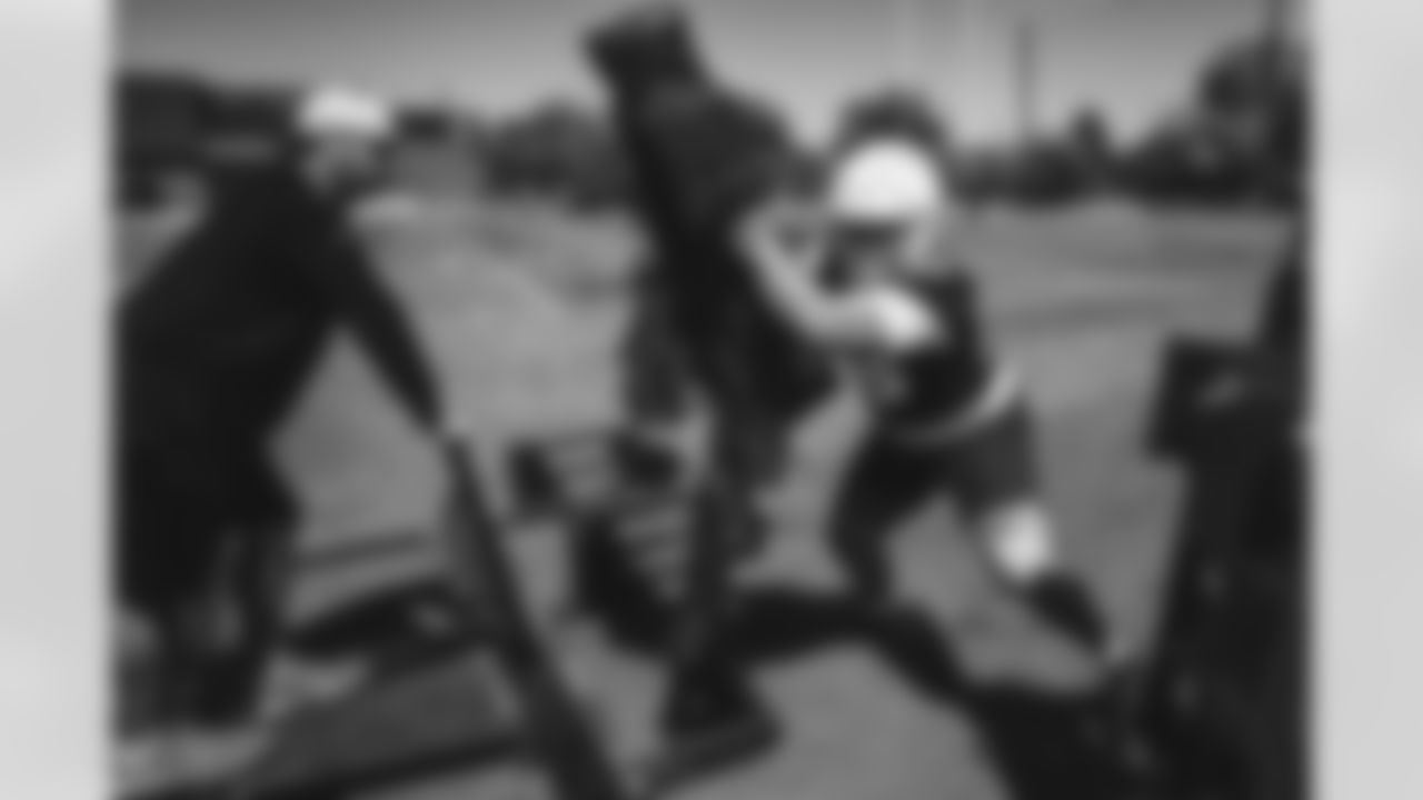 An offensive lineman works on his blocking skills with a Cardinals coach.