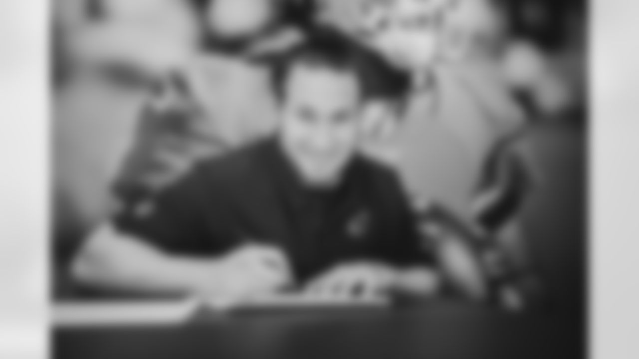 LB Dennis Gardeck smiles while signing his new contract.