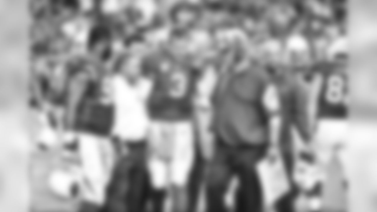 Palmer being helped off by trainers and teammates after suffering an knee injury