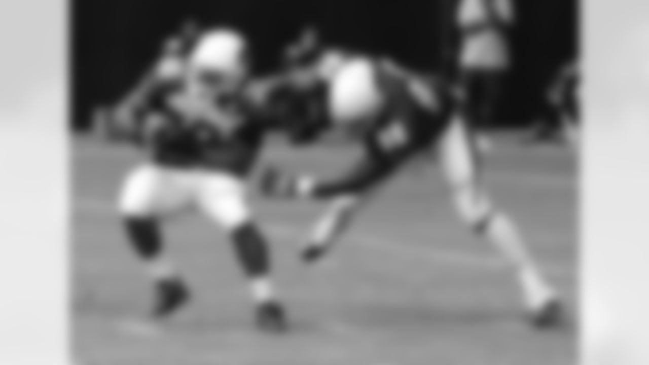 RB Stepfan Taylor (left) is grabbed by DE Frostee Rucker