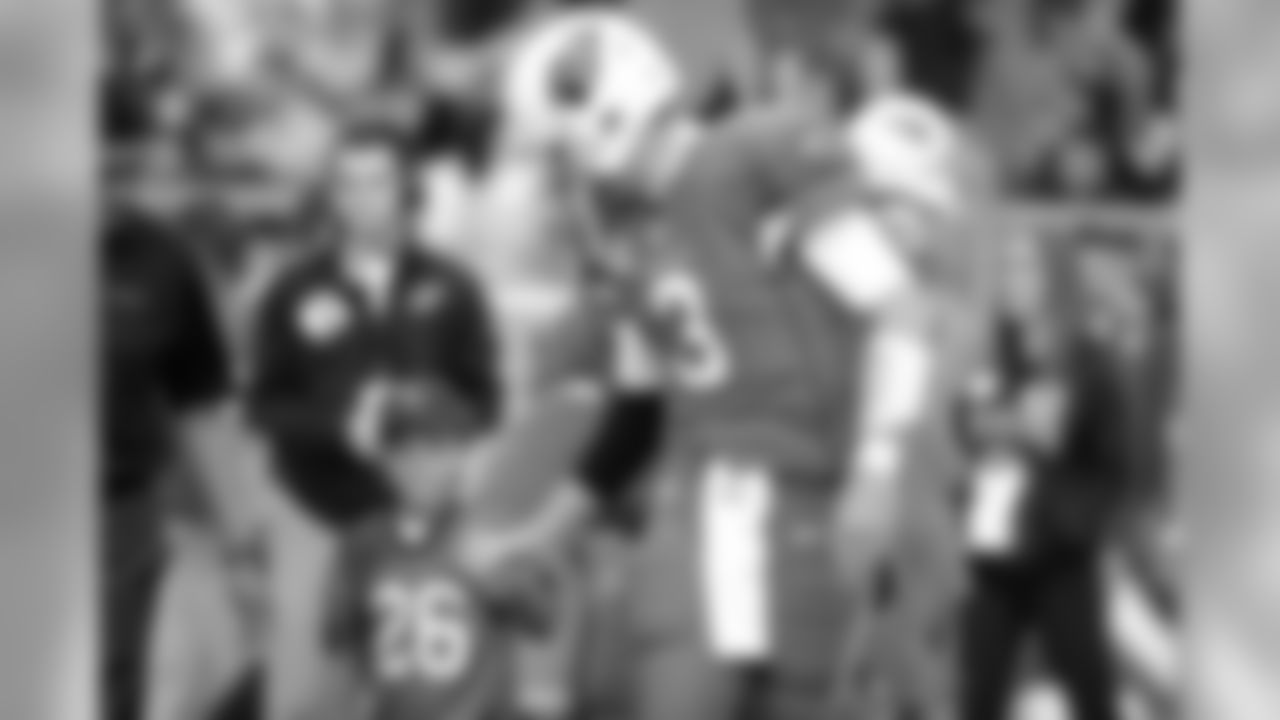 QB Carson Palmer walks to midfield with a young fan before the finale against San Francisco.