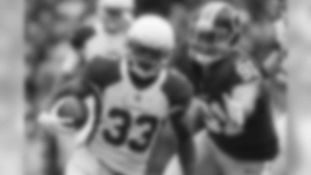 Cardinals RB Kerwynn Williams hurdles a defender