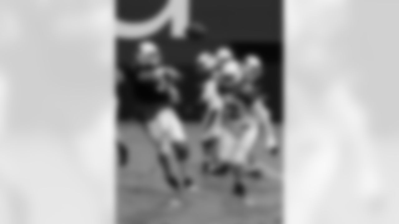 QB Carson Palmer throws a pass as DE Ed Stinson pressures him