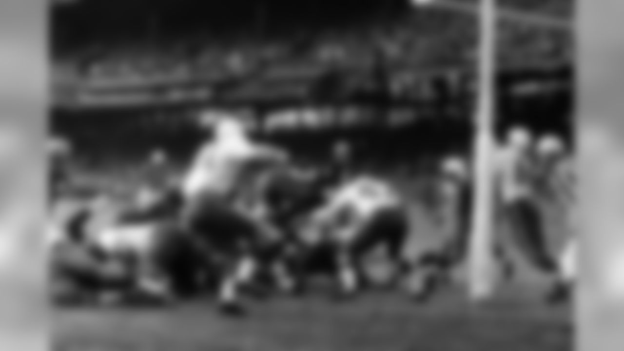 Johnny Olszewski, Washington fullback, vaults across the line for a first-quarter touchdown against the Chicago Cardinals, Nov. 9, 1958, Washington, D.C. He is headed right for Bobby Gordon (47), Cardinal back. Dick Lane of the Cards is at left. Olszewski scored from one yard out.