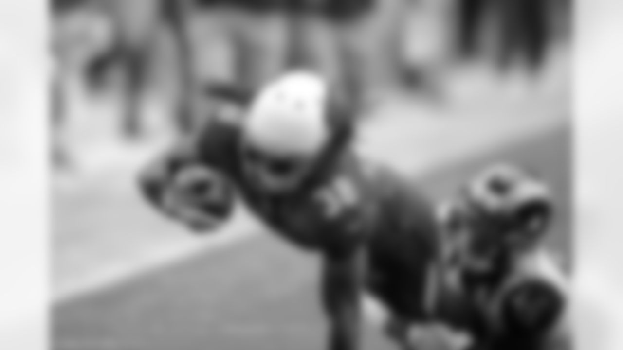 RB Andre Ellington is grabbed by Rams S Darian Stewart