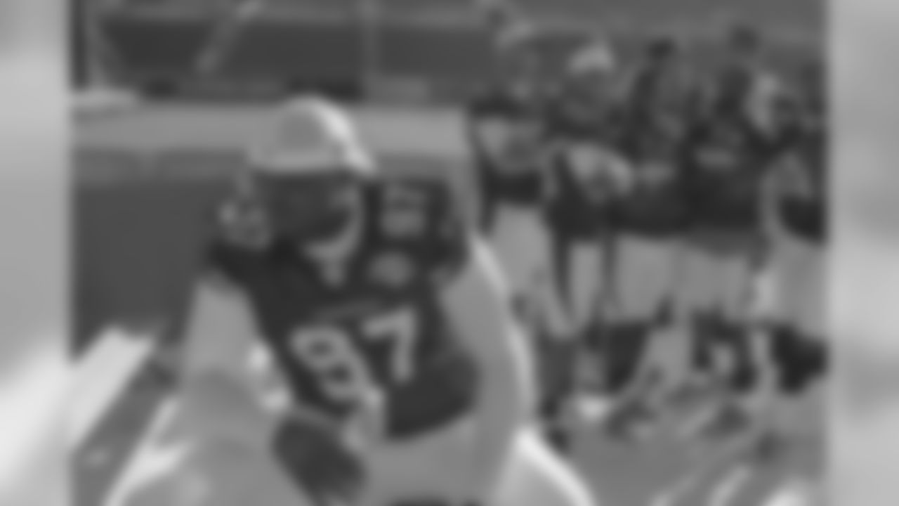 Bryan Robinson sits next to the posing defensive backs