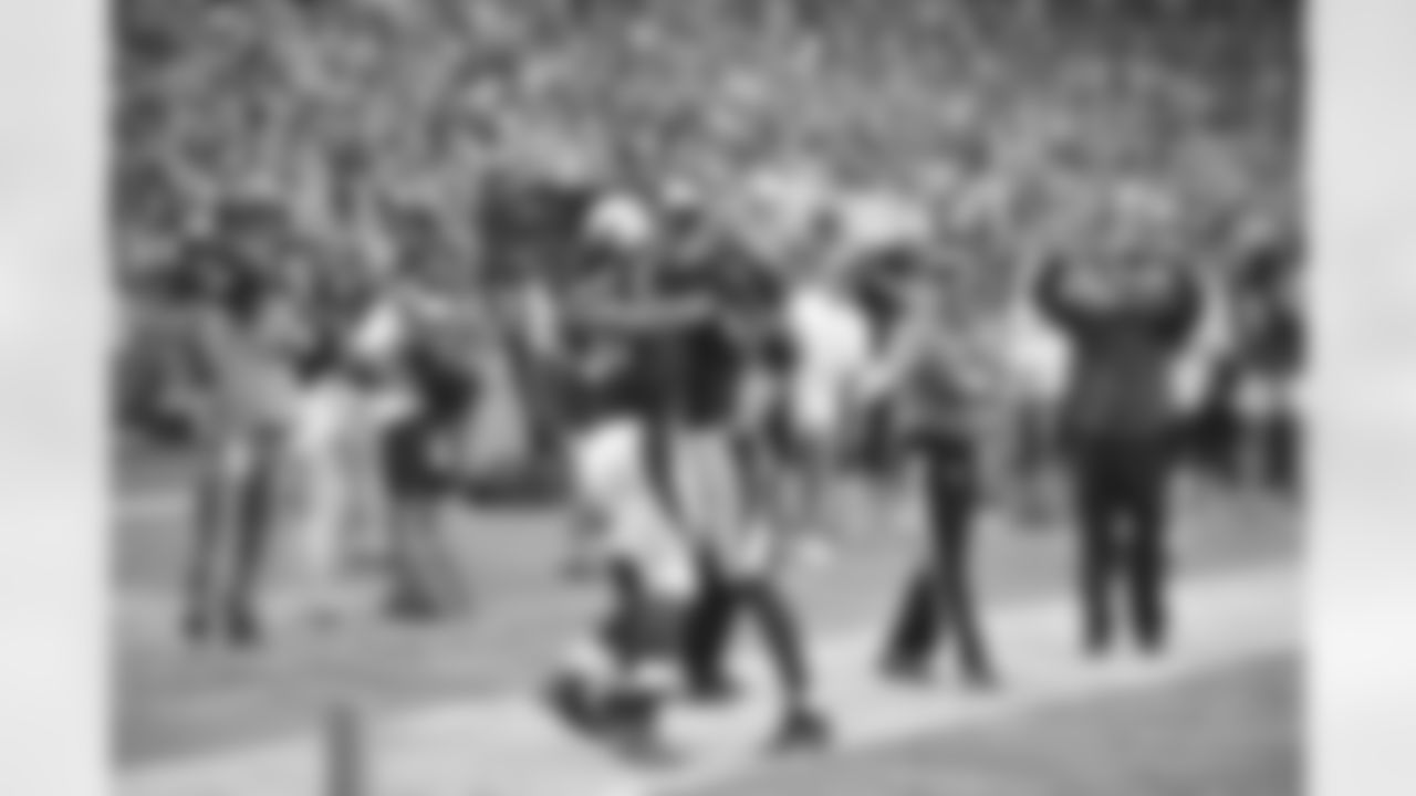 Johnson gets a celebratory hug from WR Larry Fitzgerald after scoring a game-clinching touchdown in the opener against the Saints