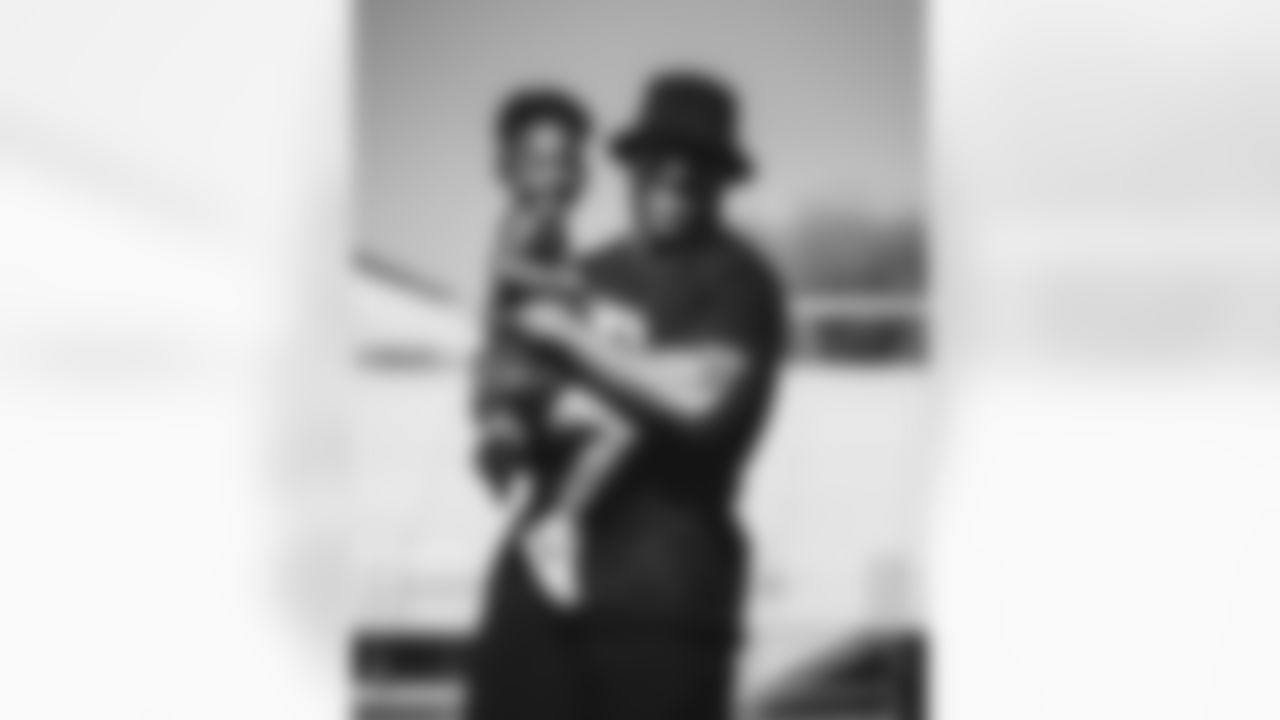 LB Devon Kennard smiles during the camp with a little girl in his arms.