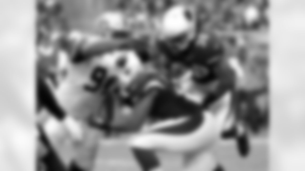 RB Andre Ellington tries to break away from Saints DE Cameron Jordan