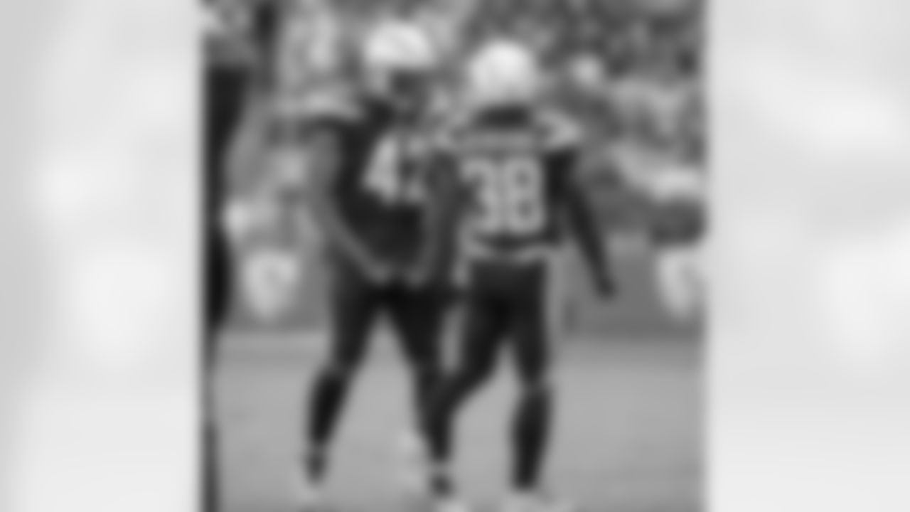 Uchenna Nwosu and Detrez Newsome laugh on the field during the Week 14 matchup against the Cincinnati Bengals at ROKiT Field at StubHub Center.