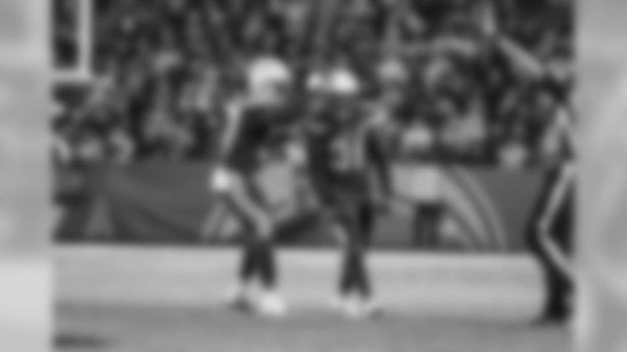 Jatavis Brown and Adrian Phillips celebrate Phillips' tackle during the Week 16 matchup against the Baltimore Ravens at ROKiT Field at StubHub Center.