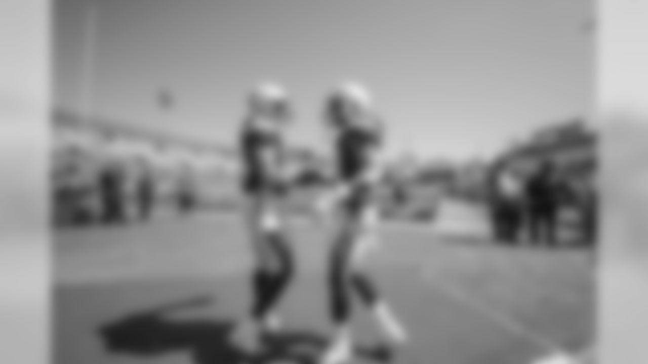 Derek Watt and Melvin Gordon share a handshake at LA Memorial Coliseum before the Bolts' matchup against the LA Rams.