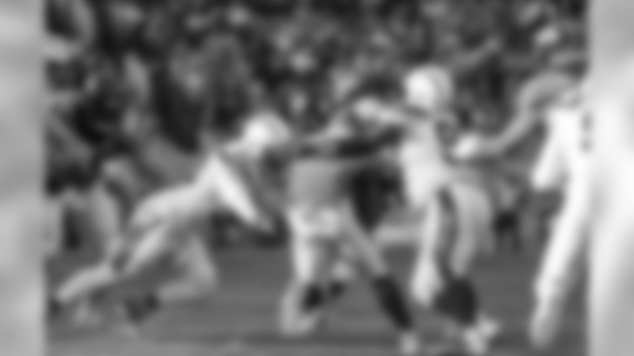 Hayes Pullard and Brandon Mebane tackle Broncos RB Royce Freeman during the Week 17 contest against the Denver Broncos.