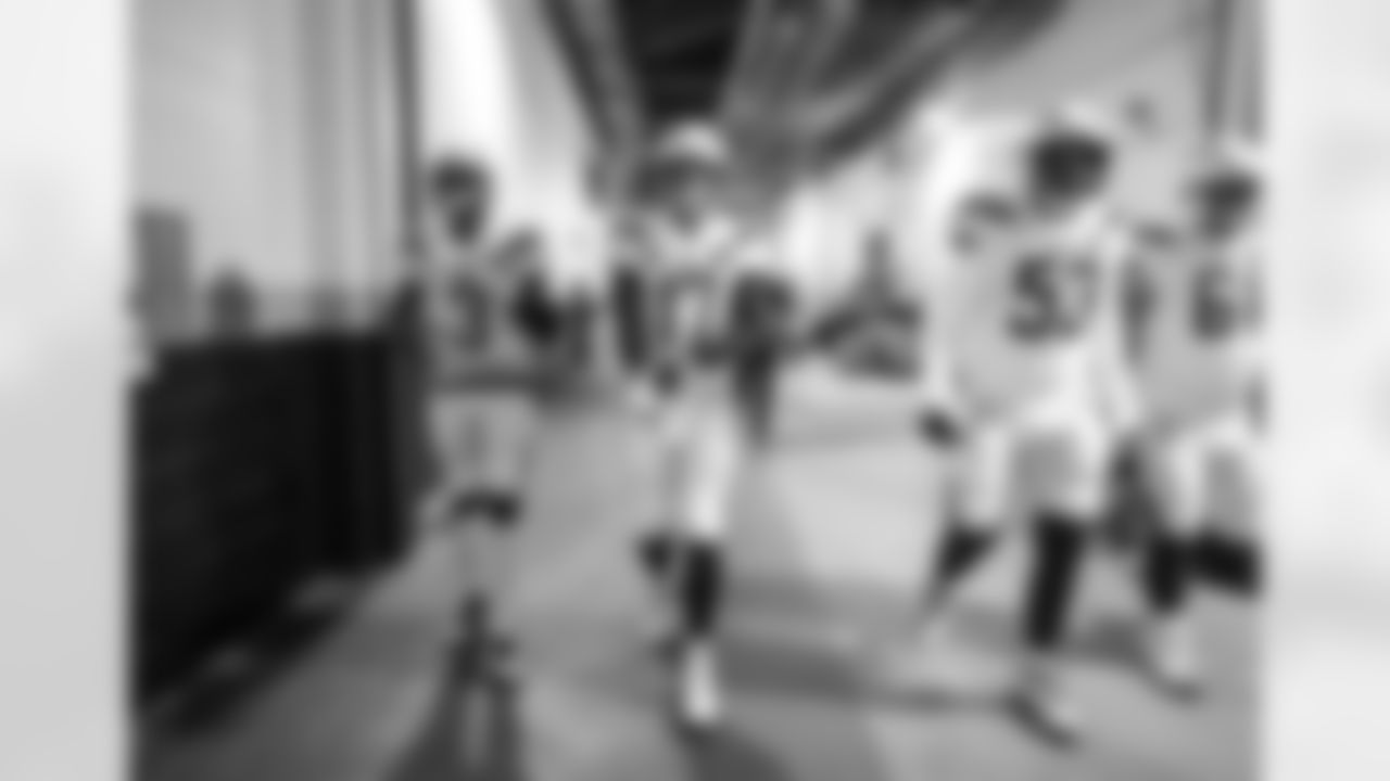Geno Smith, Philip Rivers, Mike Pouncey and Scott Quessenberry walk out to the field before the Divisional Round matchup against the New England Patriots at Gillette Stadium.