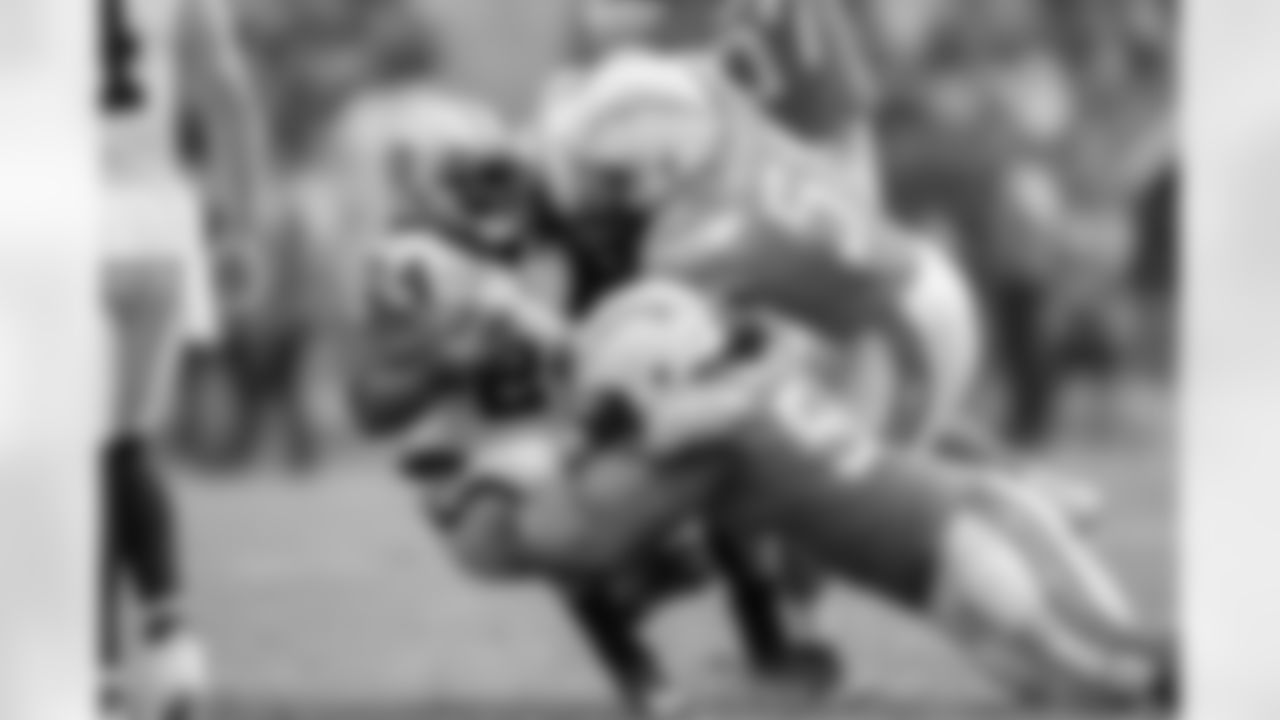 Melvin Ingram and Kyle Emanuel make a tackle during the Week 5 matchup against the Oakland Raiders at ROKiT Field at StubHub Center.