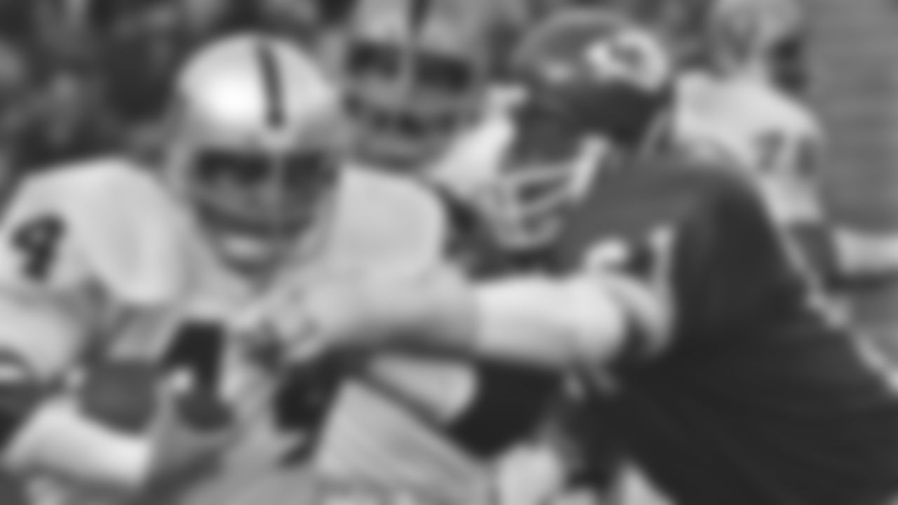 Kansas City Chiefs player Curley Culp (61) reaches to make a tackle during a game at Arrowhead Stadium in 1974 against the Los Angeles Raiders.