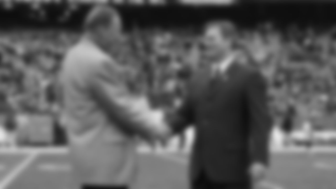 Len Dawson and Mitch Holthus shake hands on the field before a 2008 home game.