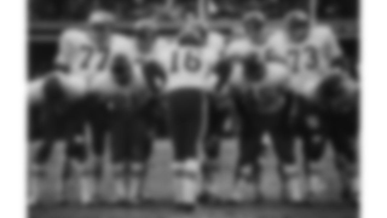Len Dawson (16) huddling with offense during a game.