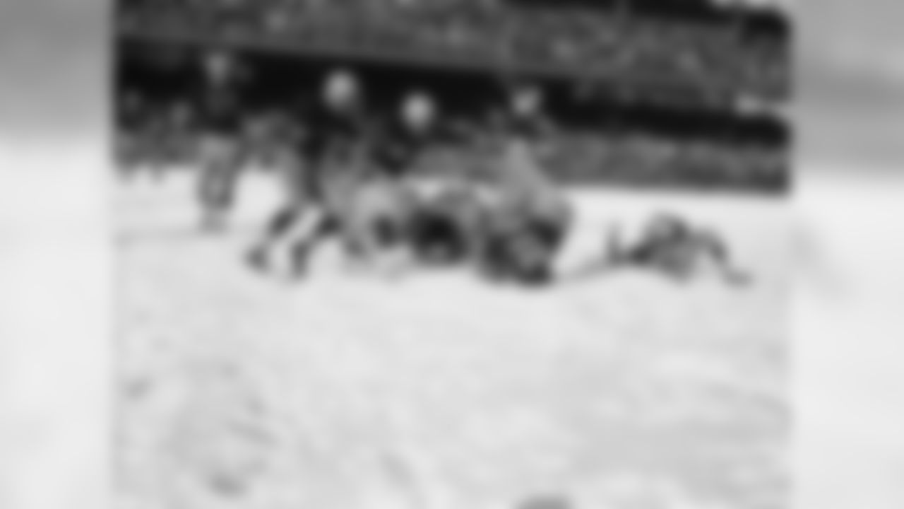 Rob Goode (21), Washington Redskins halfback, bangs his head and shoulder on the snow-covered Griffith Stadium turf with his feet in the air in the first period of a game with the Pittsburgh Steelers in Washington, on Dec. 16, 1951.