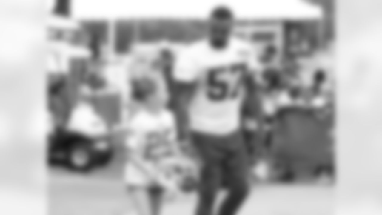 Kansas City Chiefs linebacker D.J. Alexander (57) walks with a young fan up the hill after practice on the fifth day of training camp on Mosaic Life Care Field at the campus of Missouri Western State University on Wednesday, August 3, 2016.