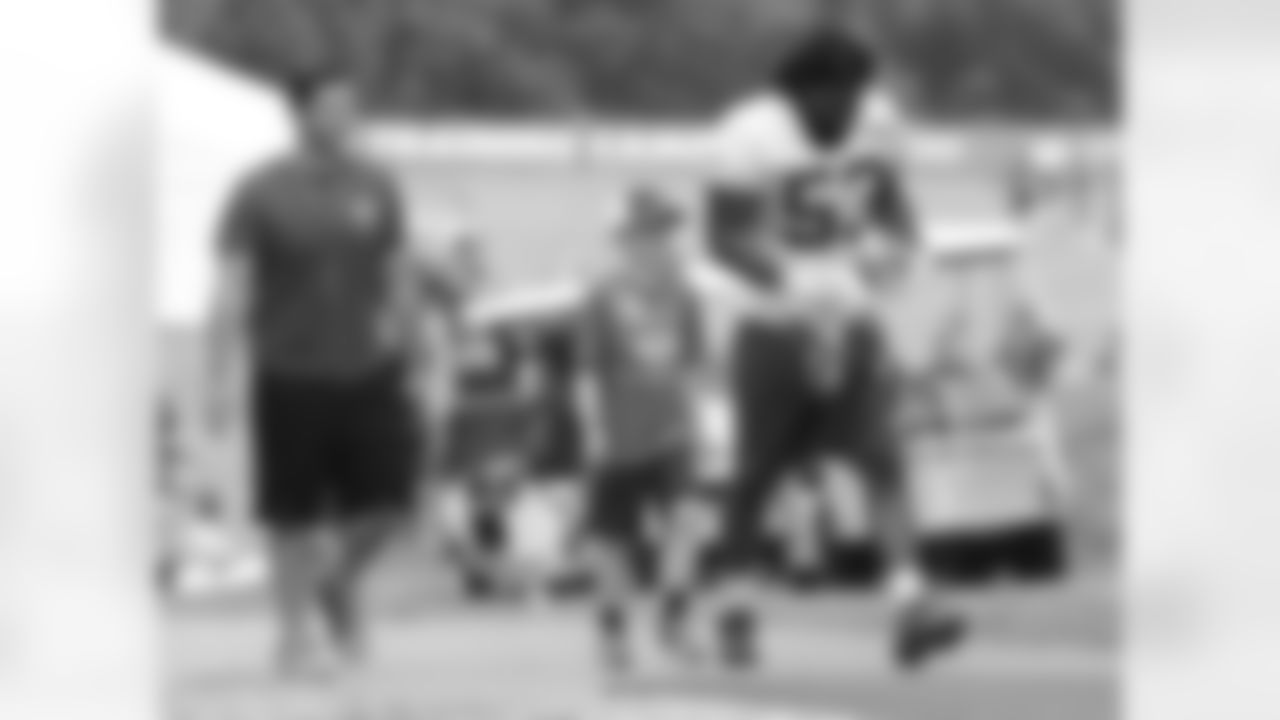 Kansas City Chiefs linebacker Ramik Wilson (53) walks up the hill with a young fan after practice on the fifth day of training camp on Mosaic Life Care Field at the campus of Missouri Western State University on Wednesday, August 3, 2016.