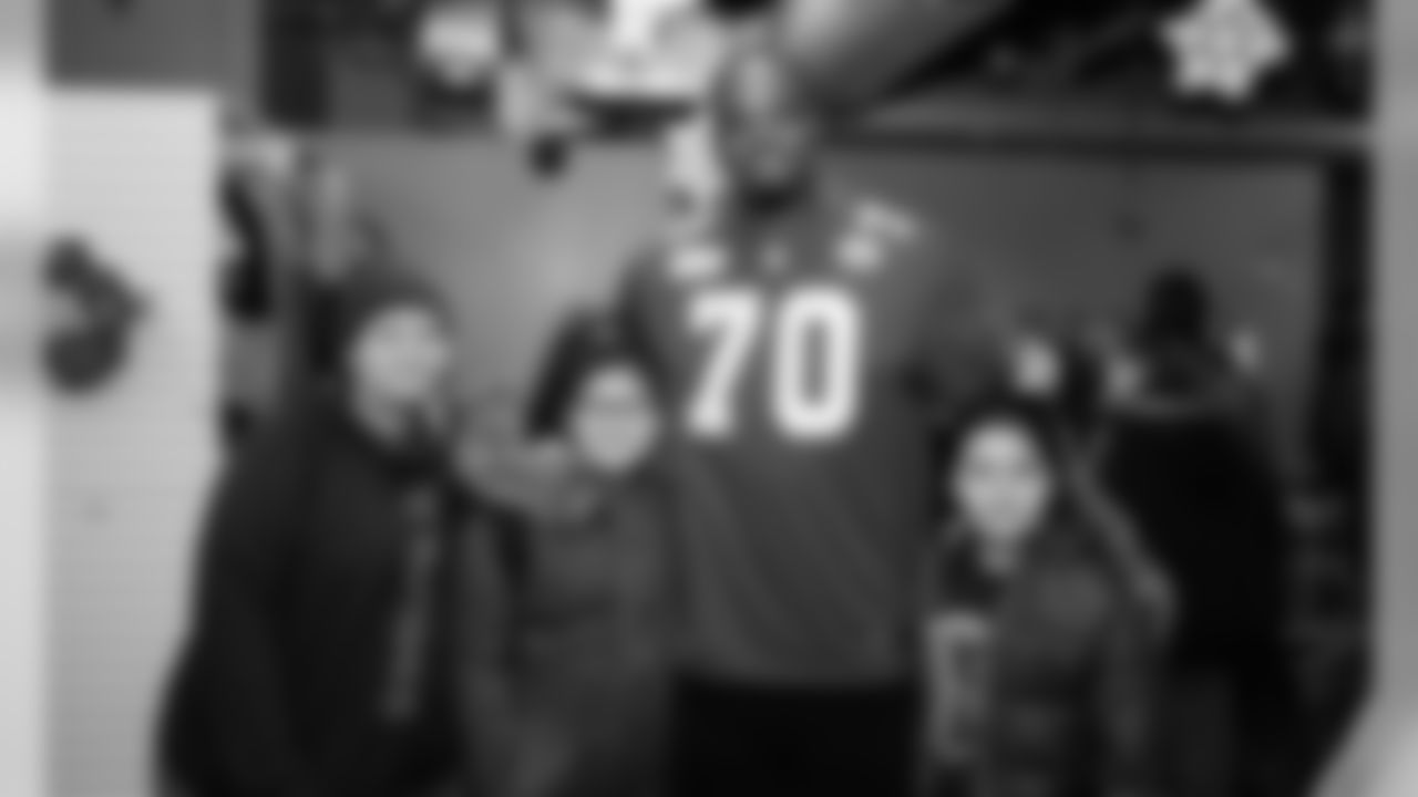 Kansas City Chiefs offensive lineman Greg Senat and Ambassador Mark Collins provide coats to families in need at the Community Services League.