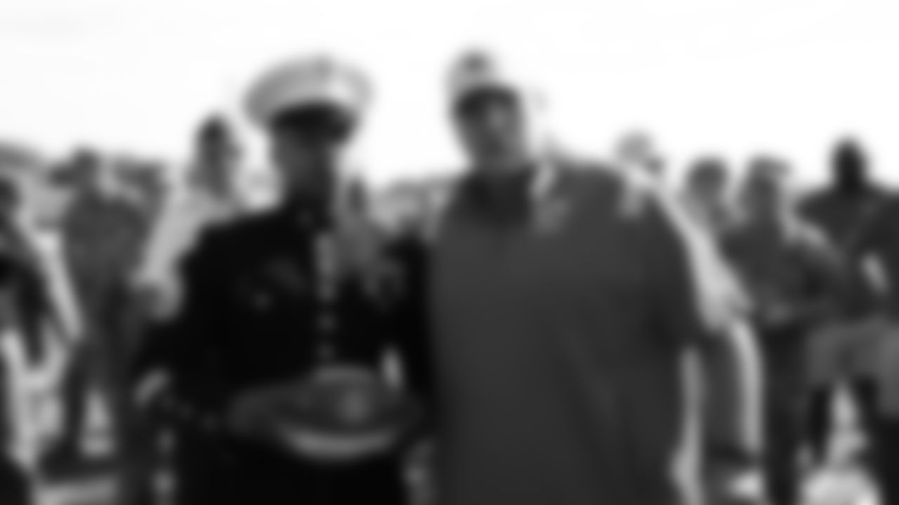 Staff Sergeant Daniel Holley from the U.S. Marine Corps receives a game ball from Kansas City Chiefs Head Coach Andy Reid after training camp practice at Missouri Western State University.