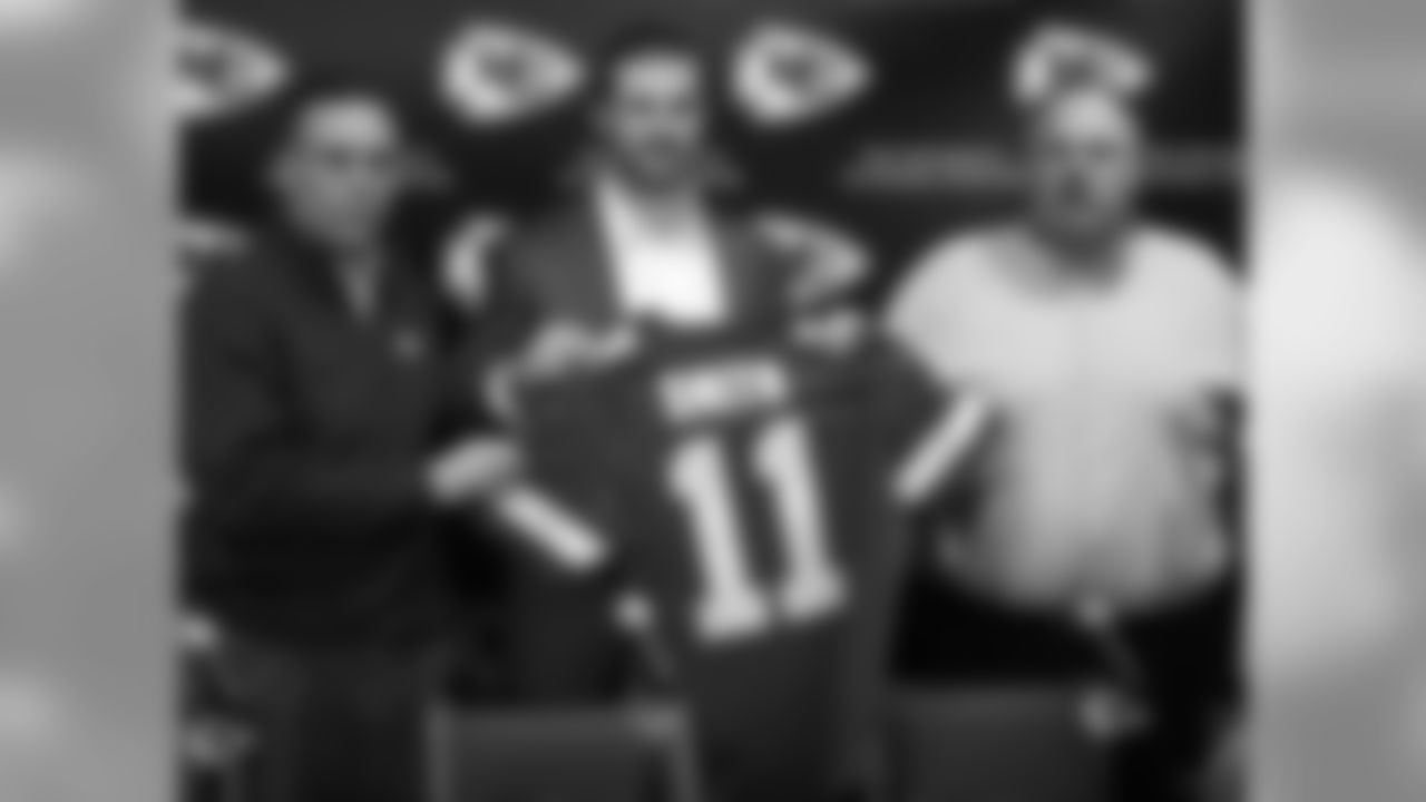 Kansas City Chiefs general manager John Dorsey, left, stands with head coach Andy Reid, right, and newly-signed quarterback Alex Smith following an NFL football news conference at the team's practice facility in Kansas City, Mo., Wednesday, March 13, 2013