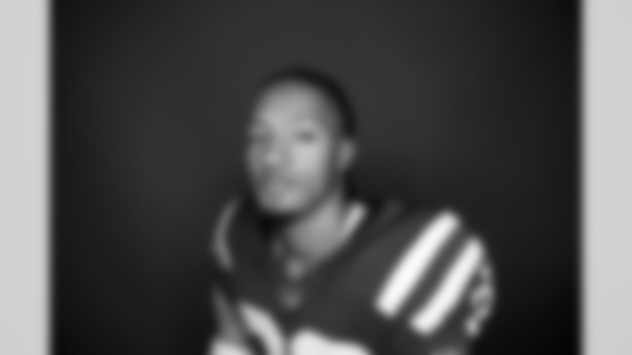 Players pose in front of a ring light for portraits on media day.